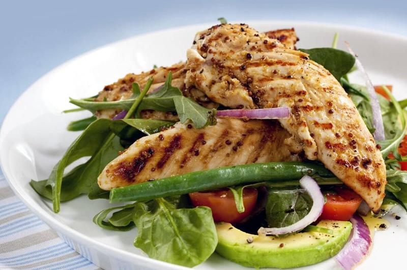 Salad of grilled chicken tenderloins with avocado, tomatoes, red onion, green beans, spinach and arugula. 